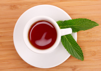 Cup  with mint on wooden background