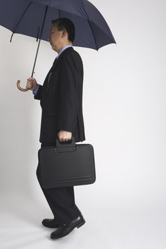傘を持つビジネスマン