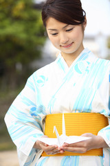 折鶴を持つ浴衣女性