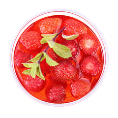 Jelly with strawberries decorated with a mint twig in a cup