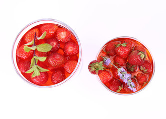 Jelly with strawberries in glass cups on white background
