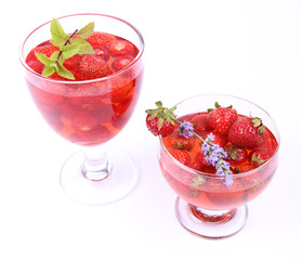 Jelly with strawberries in glass cups on white background