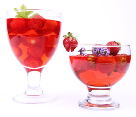 Jelly with strawberries in glass cups on white background