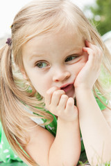 Fun little girl relaxing on a meadow