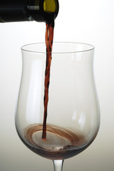 Detalle de copa de vino tinto vertiendo