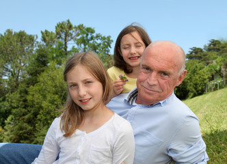 Grandfather with grandkids sitting in park