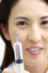 注射器を持つ女医