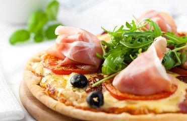 Pizza with prosciutto and arugula