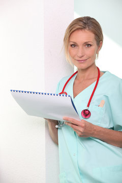 Blond Female Nurse Leaning Against Wall