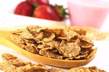 Wholewheat flake cereal on wooden spoon