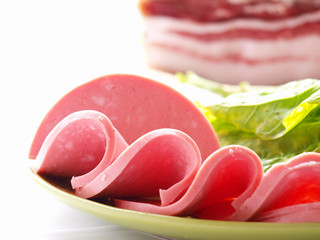 Sliced sausages  on the background of a large piece of bacon