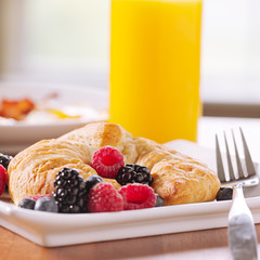 breakfast: croissant with berries and glass of orange juice