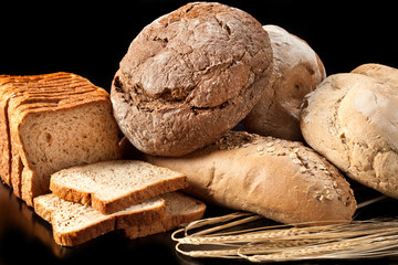 Assortment of baked bread on black background