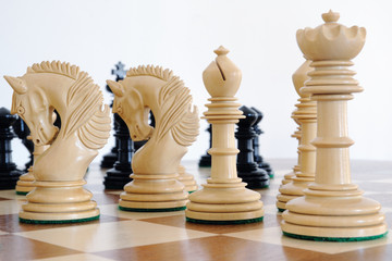 Chess pieces on wood board, black and white