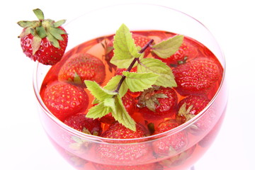 Jelly with strawberries with a mint twig in a glass cup