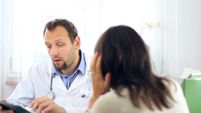 Male doctor telling bad news to female patient