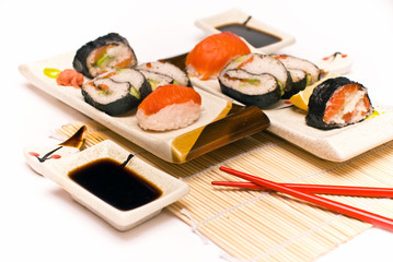 Sushi with chopsticks against white background.