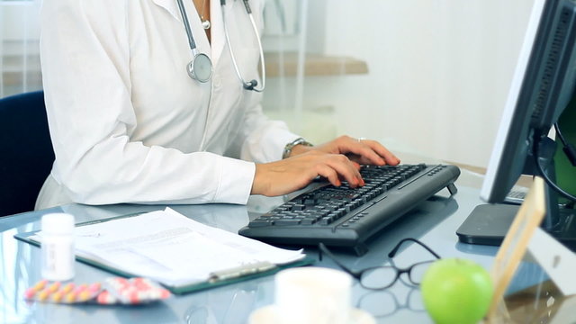 Female doctor hands working on computer