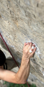 Rock climber's hand grasping handhold on cliff