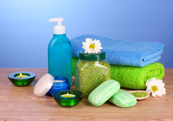 towels, sea salt, soap and candles on blue background