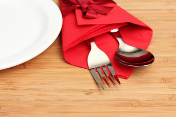 cutlery and napkin on wooden background