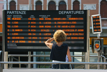 Women reads train departure infornation in Venice, Italy