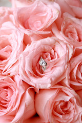 Wedding rings and pink rose bouquet