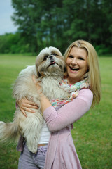 Pretty casual woman with cute little shih tzu dog outdoors in a
