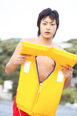 ライフジャケットを装着しようとする男性