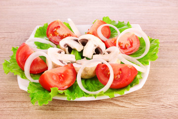 many vegetables on the plate on a wooden background