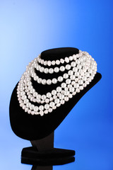pearl necklace on a mannequin on a blue background