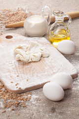 Homemade dough with flour and olive oil in the back