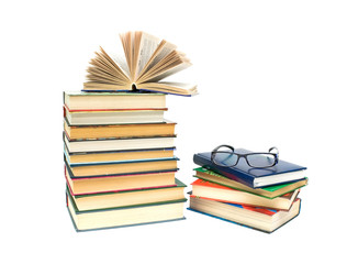 glasses and a big stack of different books isolated on a white b