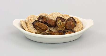 Smoked oysters with crackers in dish