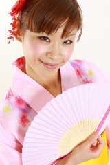 Young woman wearing Japanese kimono with paper Fan