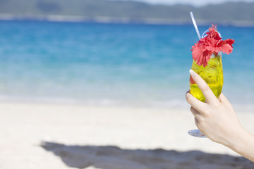 トロピカルジュースを持った女性の手元