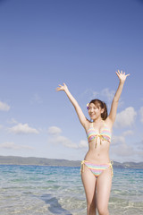 浜辺で万歳をしている水着姿の女性 Wall Mural Wallpaper Murals Paylessimages