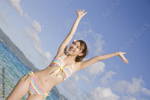 浜辺で万歳をしている水着姿の女性 Wall Mural Wallpaper Murals Paylessimages