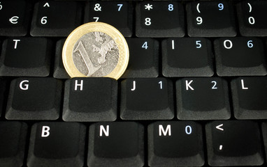 euro coin on laptop keyboard