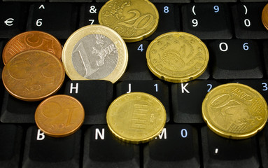 euro coin on laptop keyboard