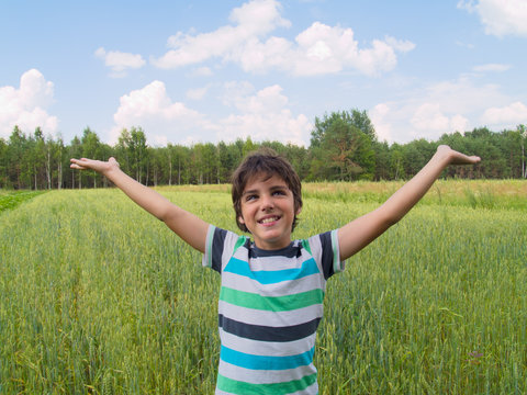 happy boy enjoying summer over wheat field