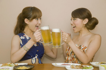 飲み会中ビールで乾杯をする女性2人