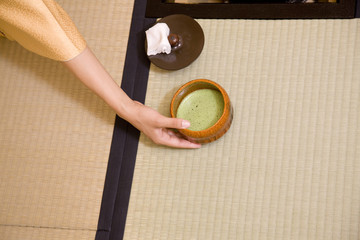 茶碗を持つ女性の手元