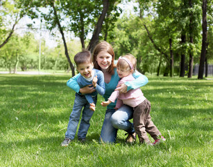 Naklejka na ściany i meble Portrait of mother and children in the park