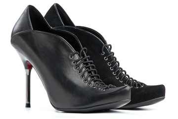 Pair of female high-heeled shoes over white