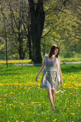 Junge Frau schlendert durch die Frühlingswiese