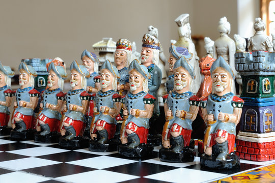 colorful ceramic figurines chess on wood board