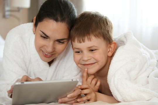 Mother and son using tablet smiling