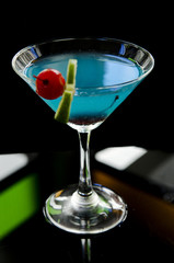 blue cocktail drink with cherry and lime