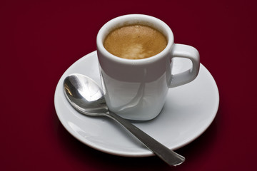 Taza de café sobre fondo rojo
